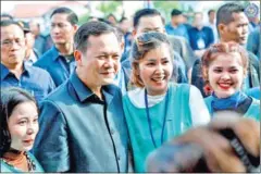  ?? LABOUR MINISTRY ?? Prime Minister Hun Manet poses for photos with factory workers recently, during which he pledged to bring passport services closer to migrant workers.