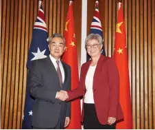  ?? — AFP photo ?? Wong (right) shaking hands with Wang before their bilateral meeting in Canberra.