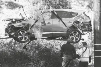  ?? RINGO H.W. CHIU/AP ?? IN THIS FEB. 23 FILE PHOTO a crane is used to lift a vehicle following a rollover accident involving golfer Tiger Woods, in the Rancho Palos Verdes suburb of Los Angeles.