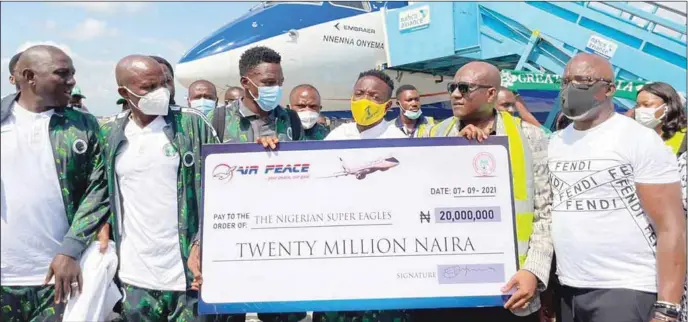  ??  ?? R-L: Chairman of Air Peace airline, Allen Oyenma, Super Eagles Captain, Ahmed Musa supported by Moses a Simon, Goalkeeper Trainer, Alloy Agu and Back up staff, Patrick Pascal receiving the dummy cheque for the N20million promised the team on arrival from Cape Verde...yesterday