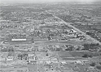  ?? THE COMMERCIAL APPEAL FILES ?? The southern area of Whitehaven is seen in this photograph from July 1953. Palmer Road is visible in the foreground and Elvis Presley Boulevard is running diagonally at right. Whitehaven High School is at extreme right center. The oval at left center is the football stadium behind Whitehaven High School. Whitehaven Baptist Church is seen at far right center. The photograph is taken looking toward the north.