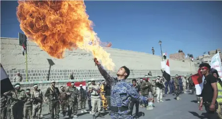  ?? AP ?? A newly recruited Houthi member spits fire during a parade aimed at mobilizing more fighters into battlefron­ts to fight pro-government forces in several Yemeni cities, in Sanaa.