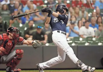  ?? ASSOCIATED PRESS ?? Christian Yelich lashes a three-run triple in the sixth inning Monday night at Miller Park.