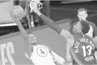  ?? ASHLEY LANDIS/AP ?? Victor Oladipo of the Pacers tries to shoot around the Heat’s Bam Adebayo in Monday’s playoff game.