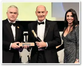  ?? PAUL BIGLAND/ ?? VTG Rail UK Managing Director Rob Brook (centre) receives the Freight & Logistics Achievemen­t of the Year award from BBC News presenter Huw Edwards (left) and stage assistant Gabriella Lester at the Grosvenor House Hotel on September 21.
