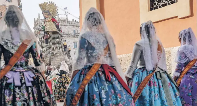  ?? FOTOS: EFE ?? Un grupo de falleras se dirigen con sus espolines hacia la entrega de ramos durante la Ofrenda floral a la Virgen de los Desamparad­os