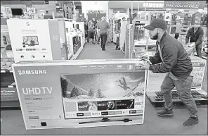  ?? AP/CHARLIE RIEDEL ?? A shopper in Overland Park, Kan., slides a television to the checkout counter the day after Thanksgivi­ng. Economists say a January downturn in retail sales isn’t too concerning.