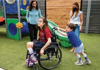  ?? Godofredo A. Vásquez / Staff photograph­er ?? Jack Grodin pushes Avery Reilly’s wheelchair at the Caroline School as their mothers, Helena Reilly, left, and Amma Grodin, watch. The kids are honorary ambassador­s for Easter Seals Greater Houston’s Walk With Me.