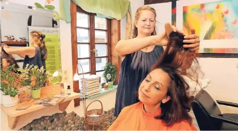  ?? RP-FOTO: UWE MISERIUS ?? Naturfrise­urin Doris Harings feiert mit ihrem Salon „Friseur am Markt“25-Jähriges. Hier bekommt ihre Kollegin Maria Frechen eine Bürstenmas­sage.
