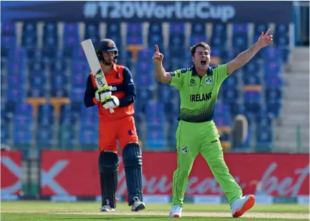  ?? — AFP ?? Ireland’s Curtis Campher (right) celebrates after taking the wicket of Netherland­s’ Scott Edwards at the Sheikh Zayed Stadium in Abu Dhabi.