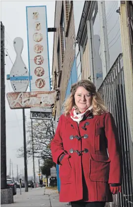  ?? PHOTOGRAPH BY BARRY GRAY, THE HAMILTON SPECTATOR ?? Julie Turner with the faded Bowlero sign in the background along Barton Street East. Turner is an artist who has produced a series of screen prints of iconic Hamilton neon signs.