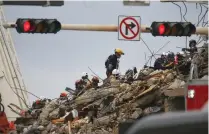  ?? (Marco Bello/Reuters) ?? RESCUE PERSONNEL continue the search and rescue operation for survivors at the site of a partially collapsed residentia­l building in Surfside, Florida, on Wednesday.