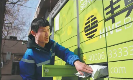  ?? ZHAO YIMENG / CHINA DAILY ?? Courier Chen Bin places a parcel inside a Hive Box locker at a residentia­l community in Beijing’s Dongcheng district on Feb 10.