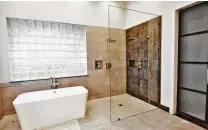  ?? Photo courtesy of Legal Eagle Contractor­s ?? A clear glass shower panel makes this room seem brighter and larger.