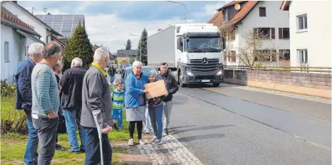  ?? FOTO: CHRISTOPH KLAWITTER ?? „Wir wollen einen Bürgerstei­g“steht auf dem Schild, während im Hintergrun­d ein Lastwagen heranfährt.