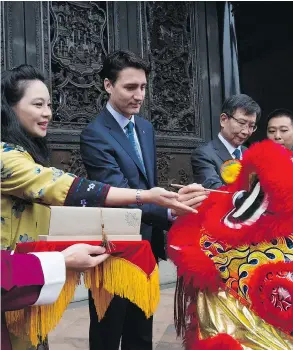  ?? SEAN KILPATRICK / THE CANADIAN PRESS ?? Prime Minister Justin Trudeau takes part in an eye-dotting ceremony to awaken the lion as he is given a tour of the Chen Clan Academy in Guangzhou, China, on Thursday.