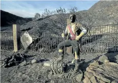  ?? DAVID McNEW/GETTY IMAGES ?? A burned pirate sculpture stands in a charred landscape in Santa Clarita, Calif. Triple-digit temperatur­es and dry conditions are fuelling the wildfire and is only 10 per cent contained.