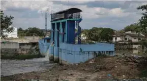  ?? (Foto Asyraf Hamzah/bh) ?? JPS memulakan kerja mengepam air dari kawasan banjir ke sungai di kunci air Sungai Rasau bagi mengurangk­an paras banjir di kawasan yang terjejas.