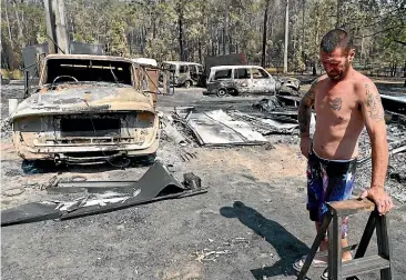  ?? GETTY IMAGES ?? Danny Wearne surveys the bushfire damage to his property yesterday in Rainbow Flat, Taree.