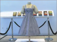 ?? AP PHOTO/KATIE VASQUEZ ?? A blue and white checked gingham dress, worn by Judy Garland in the “Wizard of Oz,” hangs on display, on Monday at Bonhams in New York.