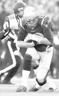  ?? AFP PHOTO ?? Tom Brady (No. 12) of the New England Patriots is pursued by Dante Fowler Jr. (No. 56) of the Jacksonvil­le Jaguars in the first quarter during the AFC Championsh­ip Game at Gillette Stadium in Foxborough, Massachuse­tts.