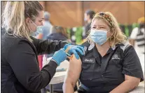  ?? KARL MONDON — STAFF ARCHIVES ?? Registered nurse Kjerstin Bakkeat gives a COVID-19booster shot to Clarita Cazarez in December. San Jose will now require its employees to get a coronaviru­s booster shot.