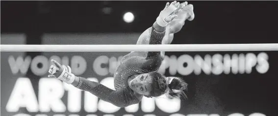  ?? Marijan Murat / Associated Press ?? Spring’s Simone Biles works on her uneven bars routine Tuesday during practice for the gymnastics world championsh­ips in Stuttgart, Germany.