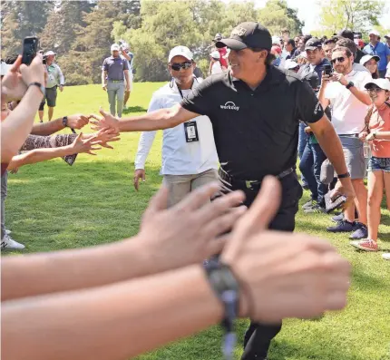  ?? ORLANDO RAMIREZ/USA TODAY SPORTS ?? Phil Mickelson, interactin­g with fans during the final round, completed a comeback by winning a playoff and earning his 43rd PGA Tour title Sunday in the World Golf Championsh­ips-Mexico Championsh­ip.