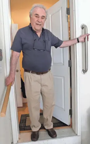  ?? MIKE DE SISTI / MILWAUKEE JOURNAL SENTINEL ?? Handrails help steady Barry Zuckerman, 79, as he steps into his garage.
