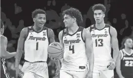  ?? SARAH STIER / GETTY IMAGES ?? Marquette’s Kam Jones, from left, Stevie Mitchell and Oso Ighodaro react in their victory over Providence in the semifinals of the Big East Tournament at Madison Square Garden on Friday night.