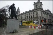  ?? AP/MATT DUNHAM ?? An anti-Brexit campaign bus drives past a statue Friday of Britain’s World War II Prime Minister Winston Churchill while doing a lap around Parliament Square for the media in London. The anti-Brexit bus is embarking on a tour around Britain and to Brussels.