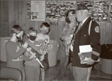  ?? Doug Walker ?? Youngsters got a chance to handle one of the American Legion Honor Guard rifles prior to the Veterans Day ceremony Wednesday. Theo Swanigan (from left), Harold David III, Toby Swanigan and Carol Green were greeted by Dan Emerick.