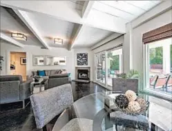  ??  ?? WHITE-PAINTED BEAMS top a living room that has a fireplace and a breakfast nook. The home is 2,235 square feet.