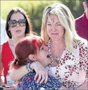  ?? AP/JOEL AUERBACH ?? Parents wait for news Wednesday outside Marjory Stoneman Douglas High School in Parkland, Fla.