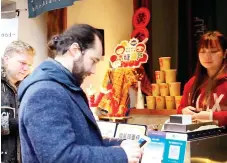  ?? ?? Internatio­nal visitors using mobile payment at a food merchant in China. Ant Group is raising the single-transactio­n limit for internatio­nal travellers using its cross-border payment services from US$1,000 to US$5,000 and the annual cumulative transactio­n limit from US$10,000 to US$50,000.