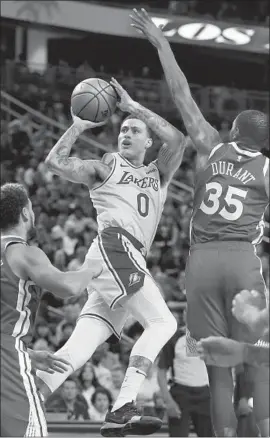  ?? John Locher Associated Press ?? KYLE KUZMA shoots around Kevin Durant of the Golden State Warriors in the Lakers’ 123-113 exhibition victory in Las Vegas. Kuzma scored 22 points.