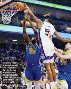  ?? (AP) ?? SACRAMENTO guard De'aaron Fox dunks over Golden State Warriors forward Draymond Green during the first half of their NBA play-in game Tuesday, April 16, 2024.