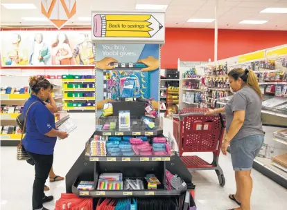  ?? Yi-Chin Lee photos / Houston Chronicle ?? Rosaria Martinez and daughter Alondra, 12, left, and Nelly Olivares shop for school supplies at the Target in the Heights.