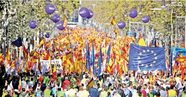  ??  ?? People hold Spanish and EU flags during a pro-unity demonstrat­ion in Barcelona. — AFP photo