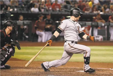  ?? Christian Petersen / TNS ?? Giants second baseman Scooter Gennett whacks an RBI single in the sixth inning of San Francisco’s 61 loss in Arizona.