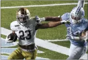  ?? GERRY BROOME — THE ASSOCIATED PRESS ?? Notre Dame running back Kyren Williams (23) runs while North Carolina linebacker Jeremiah Gemmel (44) misses the tackle during the second half of an NCAA college football game in Chapel Hill, N.C., Friday, Nov. 27, 2020.