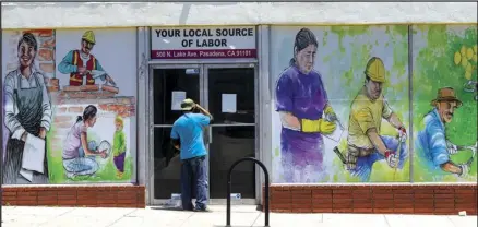  ?? ASSOCIATED PRESS ?? In this May 7, 2020 file photo, a person looks inside the closed doors of the Pasadena Community Job Center Pasadena, Calif., during the Coronaviru­s outbreak. in