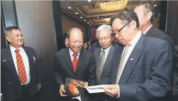  ??  ?? Abang Johari browsing through the book.