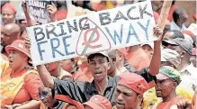  ?? | African News Agency (ANA) ?? A WORKER holds a banner during a protest march against e-tolls in the Joburg CBD. The e-tolling system that was imposed on Gauteng motorists was an attempt to extend the rule of profit and the influence of the market over our road infrastruc­ture, says the writer.