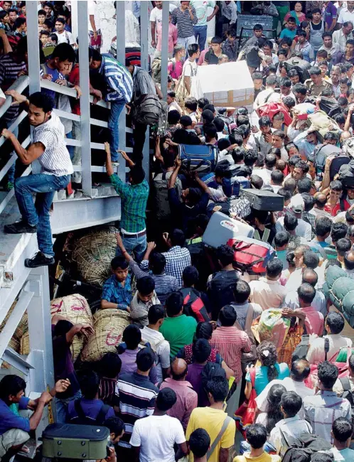  ?? AP ?? PEOPLE RETURNING FROM BANGALORE CROWD THE GUWAHATI RAILWAY STATION