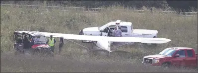  ?? The Sentinel-Record/Richard Rasmussen ?? SAFELY DOWN: Emergency personnel examine a small plane that reportedly made an emergency landing in the infield of a thoroughbr­ed training track at Double M Stables off Crystal Hill Road in western Garland County Wednesday afternoon.