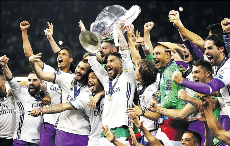  ?? — GETTY IMAGES ?? Elated Real Madrid players pose with the Champions trophy after beating Juventus 4-1 in Saturday’s final in Wales. It was the team’s third league title in four years.