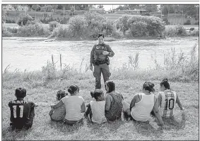  ?? The New York Times/ILANA PANICH-LINSMAN ?? Women and children wait in May to be processed by Border Patrol personnel after they tried to cross illegally into the United States at Eagle Pass, Texas. New rules that would allow federal officials to detain unauthoriz­ed migrant children with their parents indefinite­ly were blocked Friday by a federal judge.