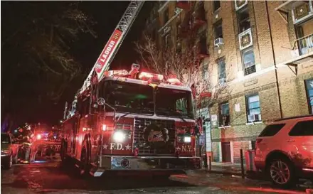  ?? REUTERS PIC ?? New York Fire Department personnel at the scene of an apartment fire in Bronx, New York, on Thursday.