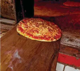  ?? Lisa Nichols/ Hearst CT Media/Lisa Nichols ?? Hot pizza being pulled out of the oven at Sally's Apizza in New Haven on April 23, 2021.